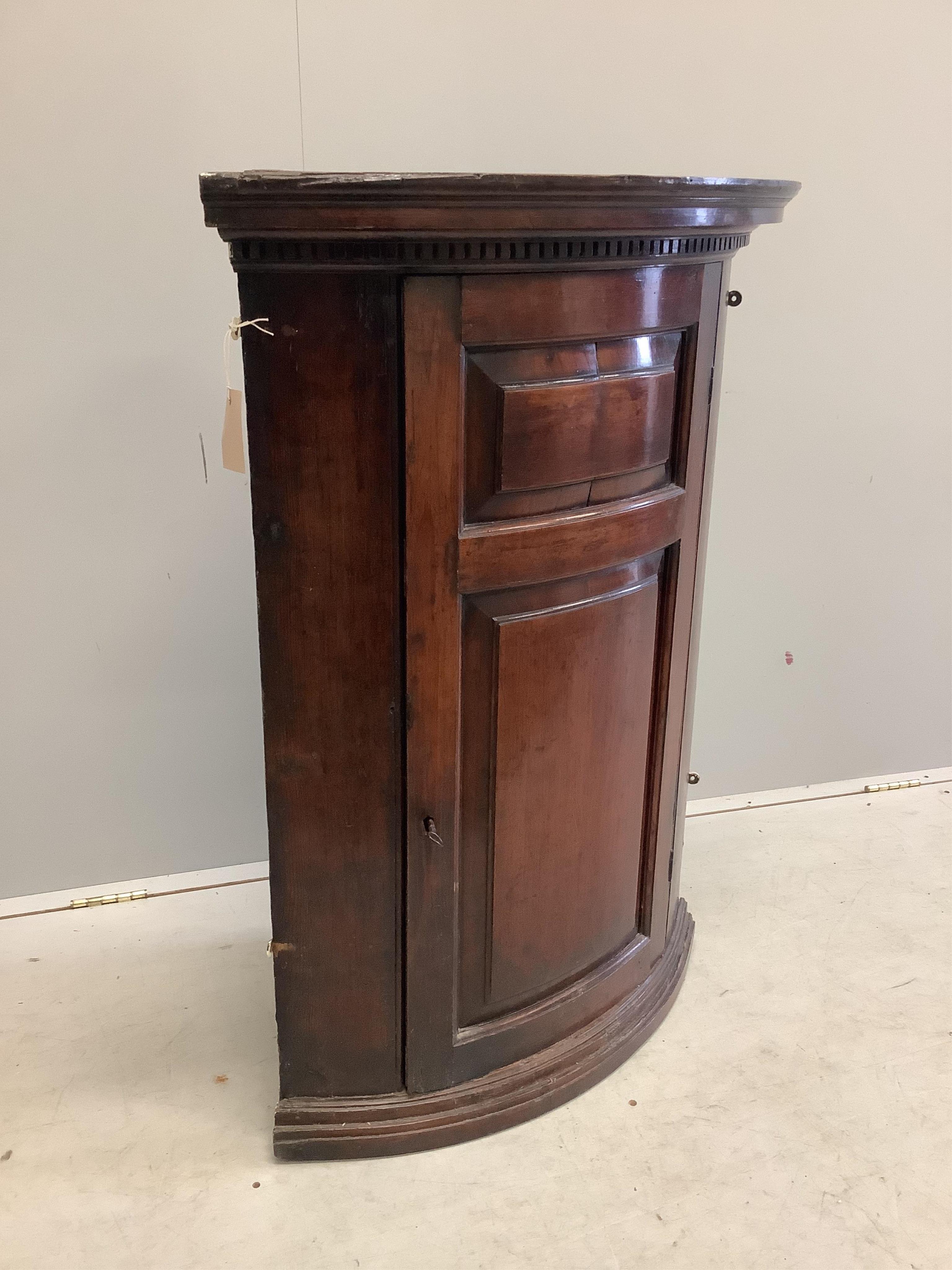 An 18th century pine bow front hanging corner cupboard, width 72cm, depth 46cm, height 101cm. Condition - fair to good